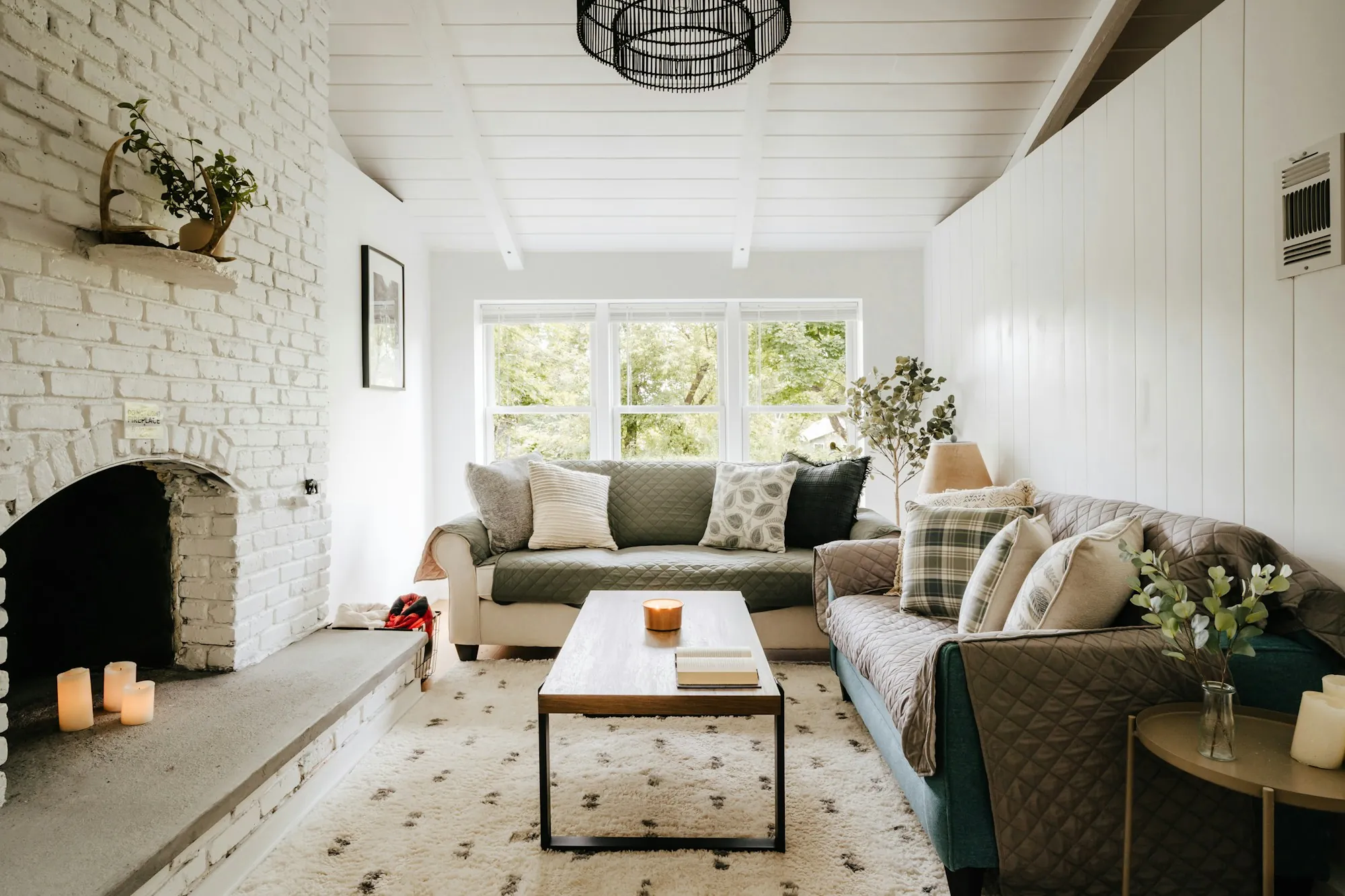 Cozy living room with a white brick fireplace and plaid pillows